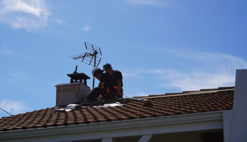 Couvreurs zingueurs BTAO réparant une toiture en tuiles